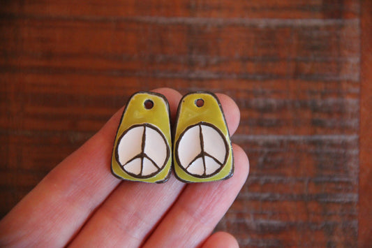 A pair of PEACE ceramic earring dangles