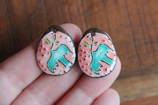 A pair of PEACE DOVE ceramic earring dangles